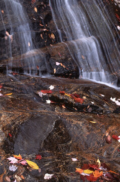 closeup slight telephoto of cascade waterfalls Yellowstone Falls autumn leaves striated granite
