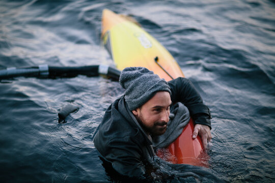 Young man sinking in Kayak, swims in chilly New England waters