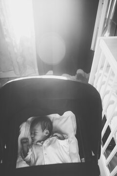 One week old baby boy in a bassinet in his bedroom