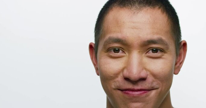 Close up portrait of an Asian man looking into camera smiling.