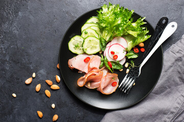 Breakfast, snack, ketogenic food. Sausage, salami, egg, cucumber, lettuce, delicious plate for a snack, lunch. View from above.