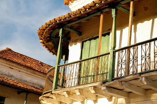View to traditional wooden balcony wit green door in sunlight, Santa Cruz de Mompox, Colombia, World Heritage