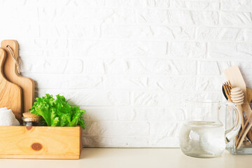 Shelf in a white kitchen with fresh fruits, herbs, cutlery, kitchen utensils, tools, textiles, fresh water in a decanter. Home, family, simplicity,