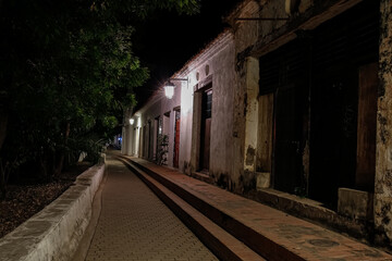 View to typical one story buildings at night in light of lanterns at the promenade of, Santa Cruz de Mompox, Colombia, World Heritage