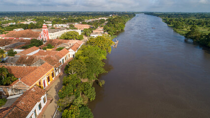 Aerial view of the historic town Santa Cruz de Mompox in sunlight with river and green sourrounding, World Heritage
