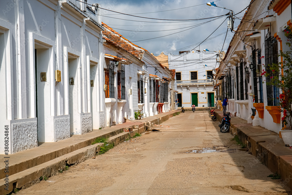 Wall mural typical street with white historic buildings in sun and shadow of santa cruz de mompox, colombia, wo