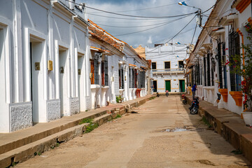 Fototapeta na wymiar Typical street with white historic buildings in sun and shadow of Santa Cruz de Mompox, Colombia, World Heritage