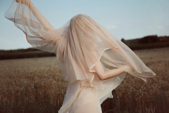 woman in transparent dress and veil dancing outdoor