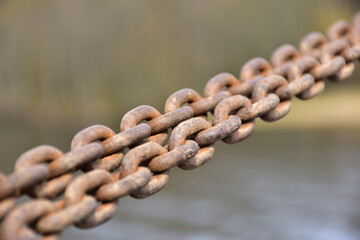 Rusty chain stretched on a boat pier
