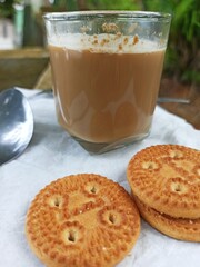 A cup of milk chocolate on a white background with crispy cake in a city park.