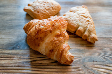 Puff pastry croissants on a wooden background.