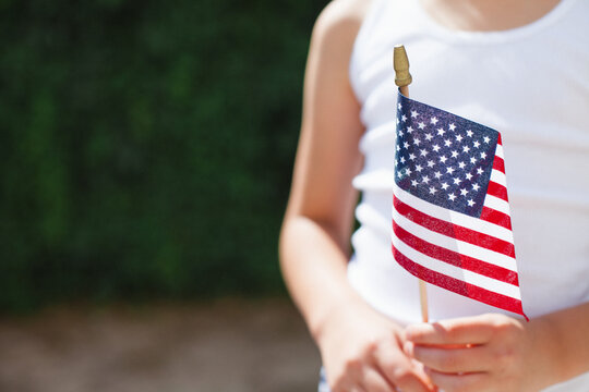 Close up of girl holding small American flag