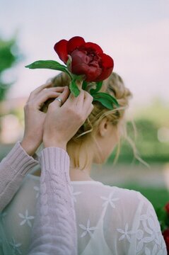 Woman decorates hair with a peony