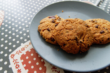 Breakfast at home with the family. Chocolate cookies served on a ceramic plate on the kitchen table.