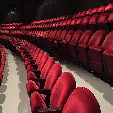 Rows Of Red Velvet Chairs In An Empty Auditorium