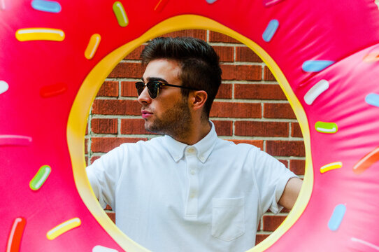 A young man posing with a donut float