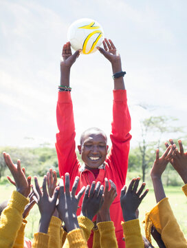 Teacher holding up football during school playtime.