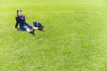 草原に座る女子高生