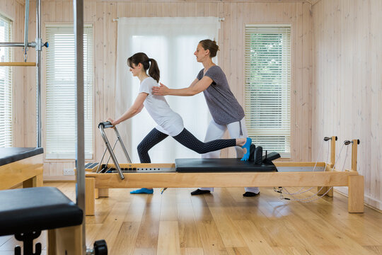 Scooter Pilates exercise being undertaken with Instructor advising on correct position.