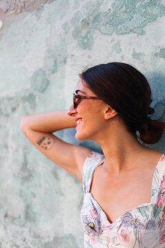 Attractive woman smiling in fron of a rural wall
