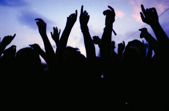 People in the crowd rising hands in a music show
