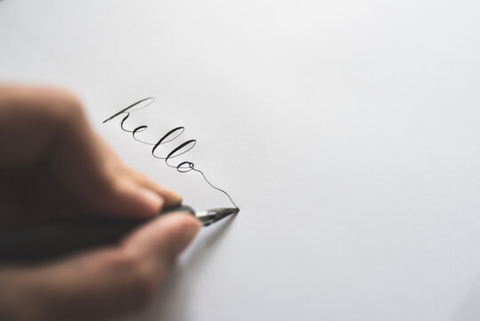 A Person Writes Out The Word Hello