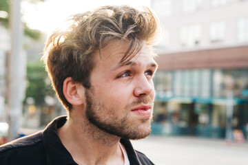 young male crying on side of street in city