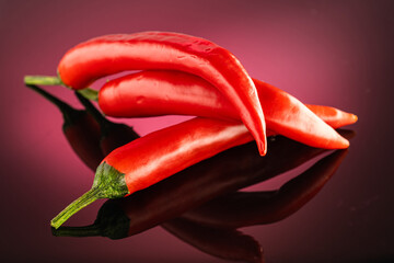 red hot long chili pepper on a red dark background