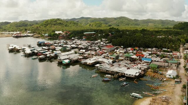 Fishing Village of stilt houses built over the sea, top view. Dapa, Siargao, Philippines.
