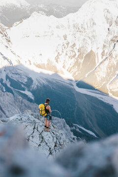 male climber peeing at the edge down the mountain