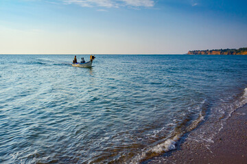 Fishing boat is crossing over calm sea