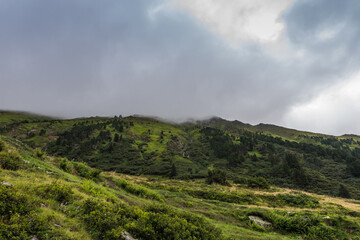 Naklejka premium green mountain landscape with rainclouds while hiking