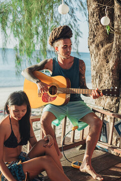 Man Playing the Guitar at the Beach