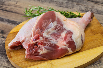 Raw duck leg served rosemary