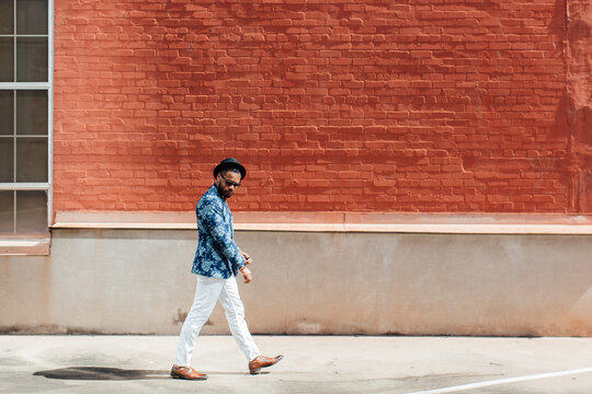 A confident walking man in dapper business attire.