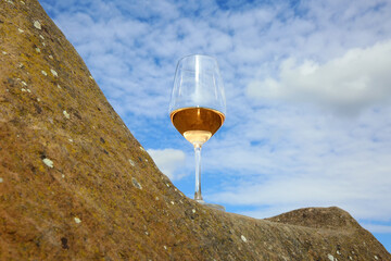 Glas mit Rosé Wein auf einem Stein