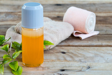 first aid with herbal oil medication liniment and bandage health care pains and aches for athlete decoration on background wooden