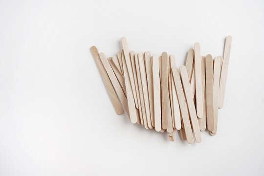 Popsicle sticks have not yet been used, stacked on top of a white background and a space for adding words.
