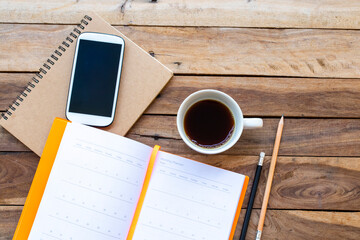 notebook planner ,mobile phone and hot coffee for business work of lifestyle arrangement flat lay style on background wooden