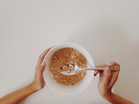 Child eating cheerios with smile face on spoon