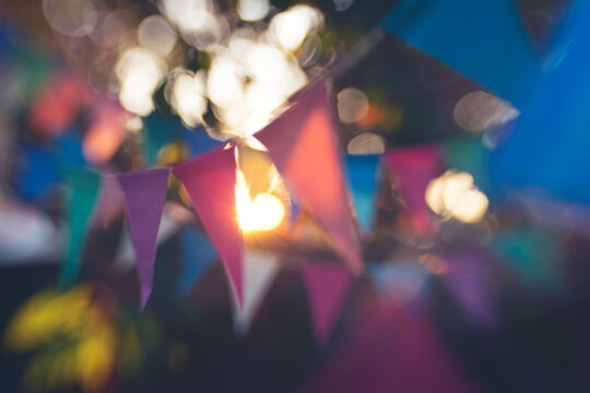 Rows of colourful paper bunting with bokeh...