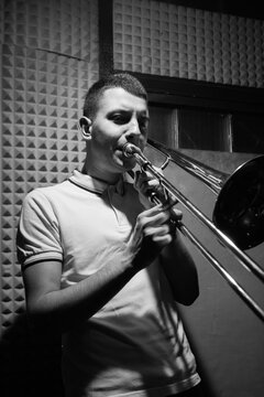 Ska/punk musician playing trombone on rehearsal om studio.