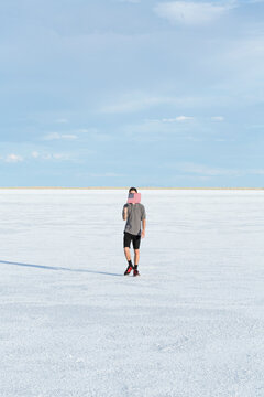 Portrait of young male waving an american flag in the salt flats of Utah