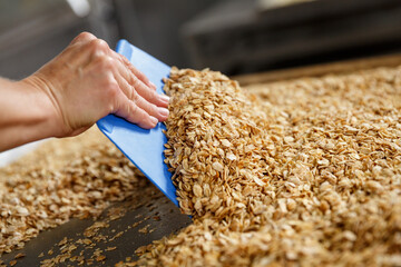 Mixing granola inrgedients after baking  them in the oven.