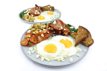 Fried eggs and bacon with a serve of spinach mushrooms and toast