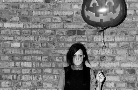 halloween portrait of young gothic woman holding Halloween Party Balloon