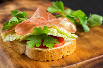 Open sandwich with ham slices on whole grain bread.