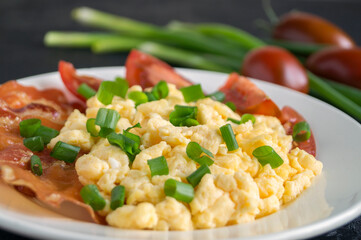 scrambled eggs with tomatoes on a white plate.