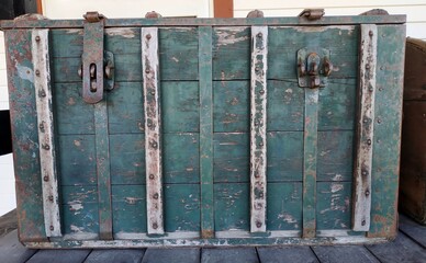 Old wooden chest displayed on cart.