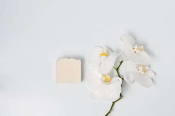 Natural handmade soap bar with orchid flowers on white table